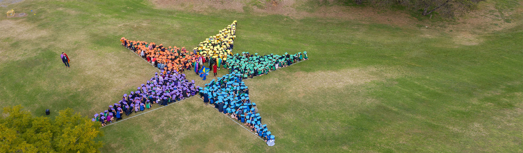 Students and staff form the shape of a star